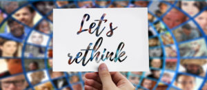 Hand holding card that says "let's rethink"